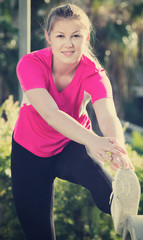 Female in pink T-shirt is doing workout
