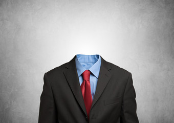 Headless businessman against a grey background