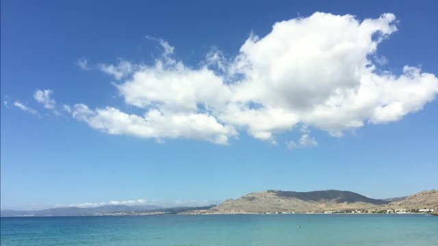 Time-lapse video of tropical clouds on blue sky with azure blue sea below. Island of Rhodes, Greece