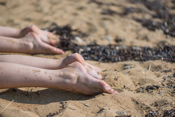 Female feet sunbathing on the beach