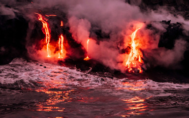 Lava is flowing from volcano Kīlauea to Pacific ocean at night © Yan