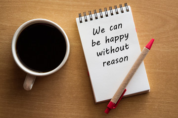 We can be happy without reason - inspirational words - handwriting on a notebook with cup of coffee