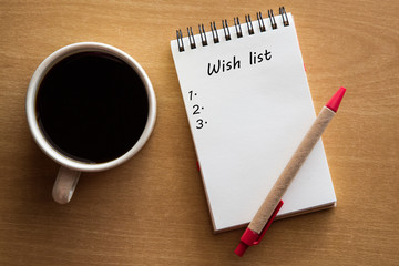 Wish list - handwriting on a notebook with cup of coffee