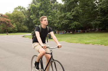 Modern young  college student ride bike in the park