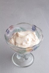 Fototapeta na wymiar Natural strawberry yoghurt in glass bowl on grey background