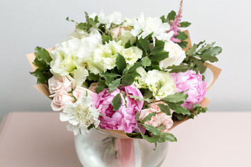 cute light bouquet with pink peonies and mixed flowers on pink dresser