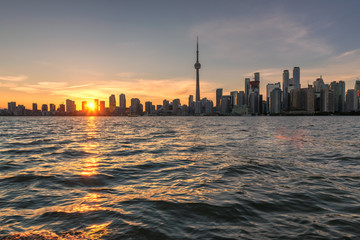 Toronto sunset over lake panorama with CN Tower, urban skyline.