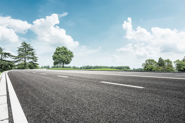 asphalt road and green tree in countryside