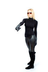 Fototapeta premium Young blonde woman in a black suit with a gun