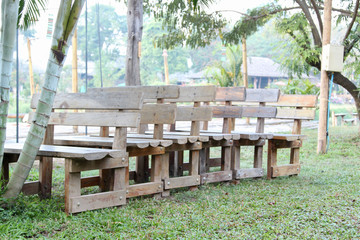 Wooden benches made of logs on green grass.