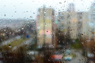 Fototapeta na wymiar Raindrops on the street window