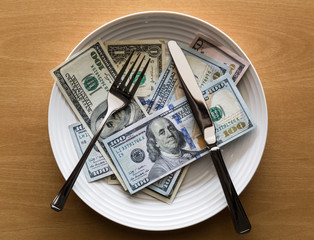 Plate full of money with fork and knife, Business concept.