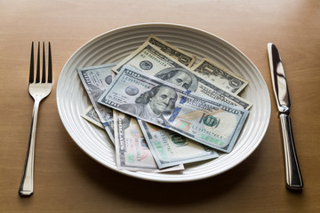 Plate full of money with fork and knife, Business concept.