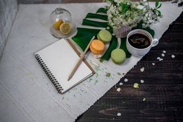 Morning tea or coffee with orange and kiwies slices and green macaroons on a white blanket with cherry blossom