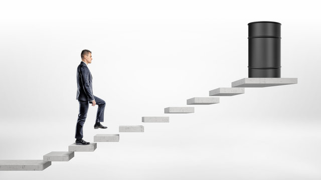 A Businessman On White Background Walking Up A Concrete Block Stairs Where A Black Oil Barrel Stands On The Top.