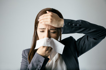 young woman blowing her nose. allergic rhinitis. hay fever.