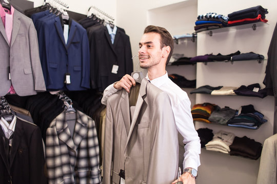 The man buyer chooses jacket the boutique