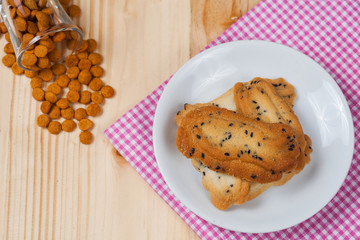 Home made a small sweet cookie with black sesame, typically round, flat, and crisp.Cookie in dish on tablecloth.