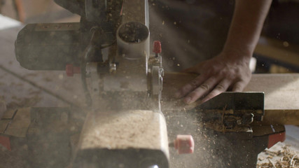 close up circular saw saws wooden plank board with sawdust in backlight