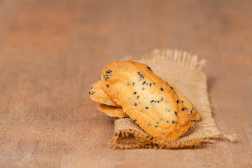 Obraz premium Home made a small sweet cookie with black sesame, typically round, flat, and crisp.Cookie in dish on sackcloth.