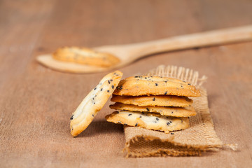 Home made a small sweet cookie with black sesame, typically round, flat, and crisp.Cookie in dish on sackcloth.