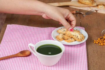 Hand hold a home made a small sweet cookie with black sesame.