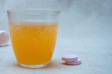 Effervescent tablet (vitamin) in a glass of water.