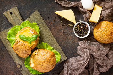 Delicious baked burger from bacon, eggs, cheese served with fresh lettuce leaves. Ingredients for cooking scrambled eggs. Top view.
