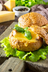 Delicious baked burger from bacon, eggs, cheese served with fresh lettuce leaves. Ingredients for cooking scrambled eggs.