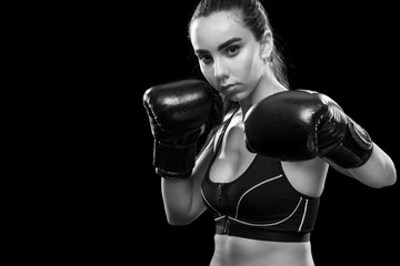 Woman boxer fighting in boxing cage. Isolated on black background. Copy Space. Black and white...