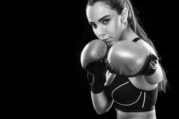 Woman boxer fighting in boxing cage. Isolated on black background. Copy Space. Black and white...