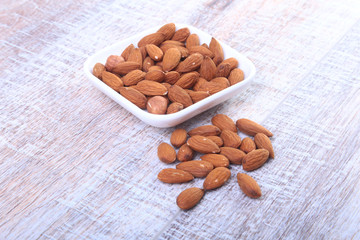 nuts almonds in white bowl on wooden background. Selective focus.