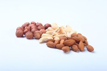 Mixed nuts from hazelnuts, almonds, cashews isolated on white background. Selective focus.