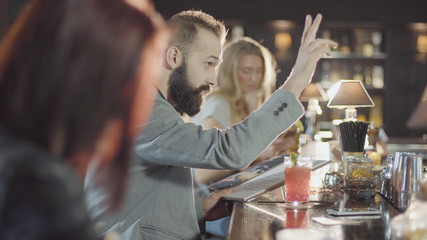 Fototapeta na wymiar 20s bearded guy people is drink cocktail sitting bar counter with menu