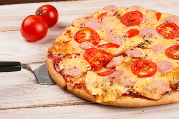 Hot pizza slice with melting cheese on a rustic wooden table