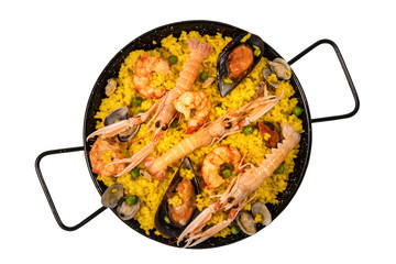 Spanish seafood paella in paellera on white background
