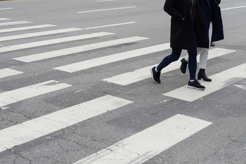 close-up on unidentified people legs crossing street