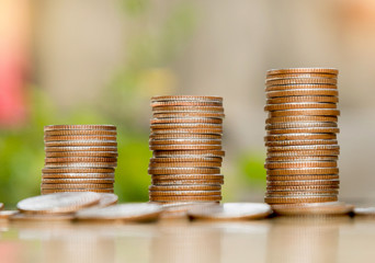 step of coins stacks on the table with nature background, money, saving and investment or family planning concept.