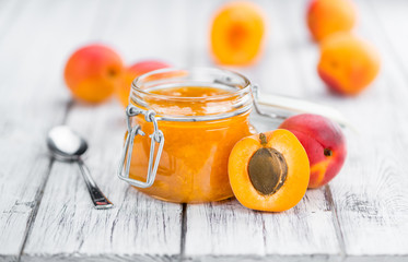 Portion of Apricot Jam on wooden background (selective focus)