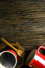 red coffee cup and mug with wood spoon in top view