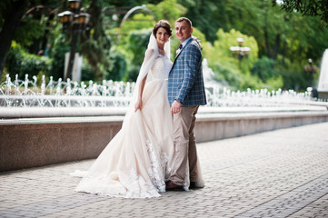 Attractive young wedding couple walking and posing in the park on a sunny day.