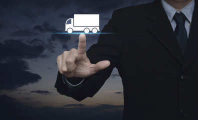 Businessman pressing truck flat icon over sunset sky, Business transportation service concept