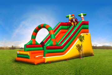 Colorful, large, inflatable children's slide on the green grass
