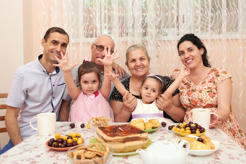 big family drinking tea in dining room