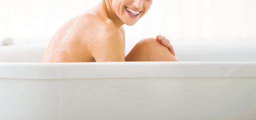 Young woman sitting in bathtub