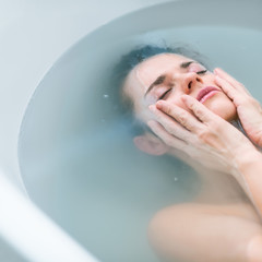 Fototapeta premium Frustrated young woman laying in bathtub