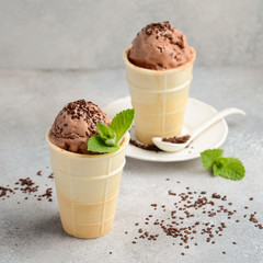 Chocolate ice cream with chocolate crumb on grey concrete background, selective focus, square format