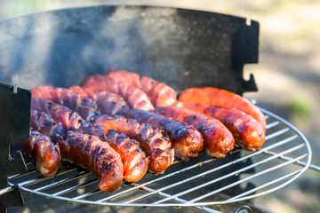 Grilled sausage on barbecue grill, picnic outdoors