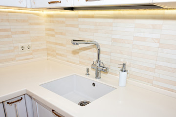Kitchen sink and faucet. Modern, bright, clean kitchen interior details.