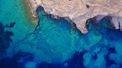 Fototapeta na wymiar Aerial drone photo of famous caves of Ksylobatis near Pori beach, Koufonissi island. Cyclades, Greece